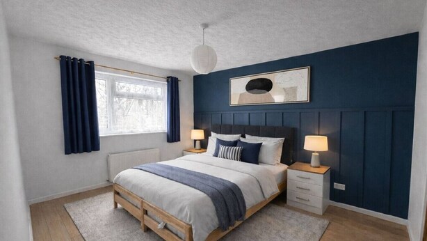 A bedroom with a bed, bedside tables, a window with curtains, a radiator, and a wall-mounted light fixture. - Charming Flat • Great Location • Free Parking • Fast WiFi • Self-Check-In (Nottingham)