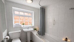 A bathroom with a toilet, sink, bathtub, and window. - Charming Flat • Great Location • Free Parking • Fast WiFi • Self-Check-In (Nottingham)