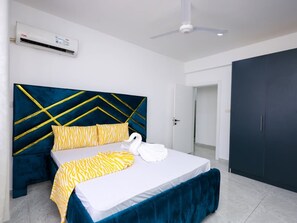 Ein Hotelzimmer mit Bett, Schrank, Deckenventilator und Klimaanlage.