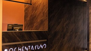 Ein Empfangsbereich mit modernem Design, inklusive einer Rezeption, einer Couch und einem gemusterten Boden.