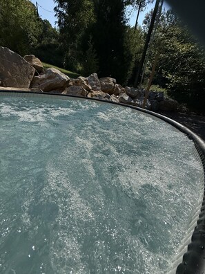 Une piscine à l’eau claire, entourée de rochers et d’arbres.