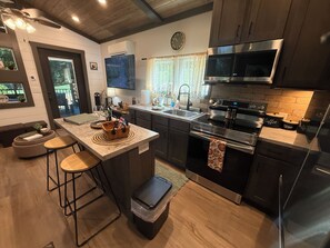 Una cocina moderna con una isla central, electrodomésticos de acero inoxidable y una zona de comedor con taburetes.
