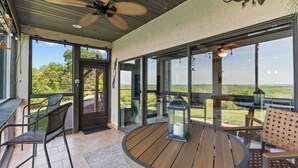 A covered outdoor area with a ceiling fan, a wooden deck, and a view of the landscape. - Sunset Ridge  Private Patio, Cliffside Lake Views (Lake Ozark)