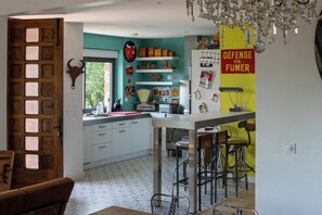 A kitchen with a white countertop, bar stools, and a refrigerator with magnets. - Top-of-the-range large-capacity gîte (Meyssac)