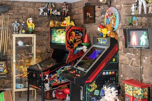 A room with arcade games, a toy collection, and a neon sign. - Top-of-the-range large-capacity gîte (Meyssac)