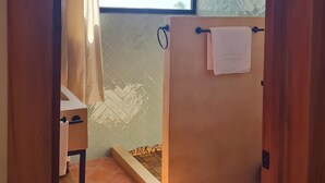 Une salle de bain avec une douche, un porte-serviettes et une fenêtre.
