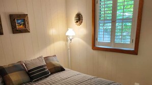 A bedroom with a bed, a lamp, a window, and a picture on the wall. - Executive 3 bedroom Cottage on private 30 Island Lake perfect for World Cup Fans (Godfrey)