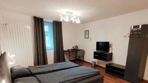 A modern bedroom with a sofa bed, a desk, a TV, and a wardrobe. - B&B Berninapass (Poschiavo)
