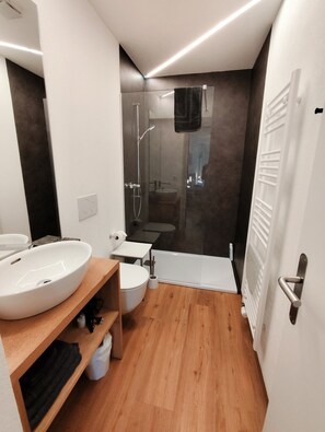 A modern bathroom with a large white sink, a toilet, a shower, and a bathtub. - B&B Berninapass (Poschiavo)