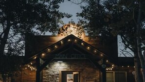 A wooden house with a stone facade, a porch with string lights, and a door labeled 'MAIN OFFICE.' - Teton Valley RV Resort (Victor)
