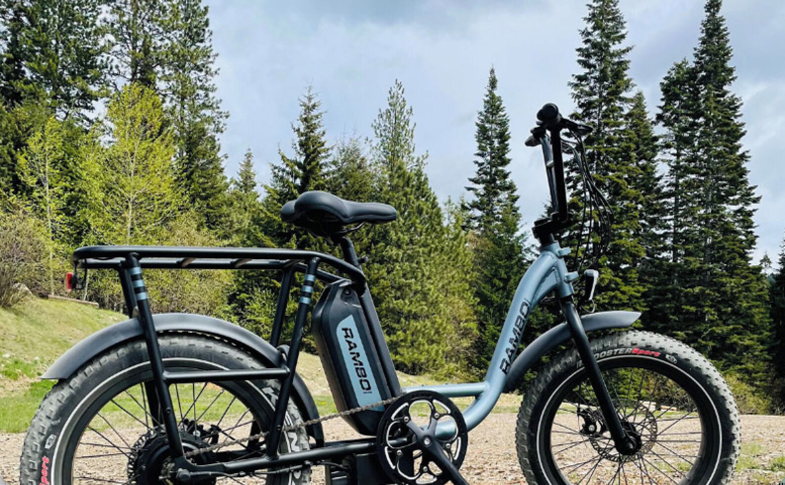 Un vélo électrique à cadre en bambou, doté d’un porte-bagages arrière, d’une suspension avant et d’un bloc batterie.