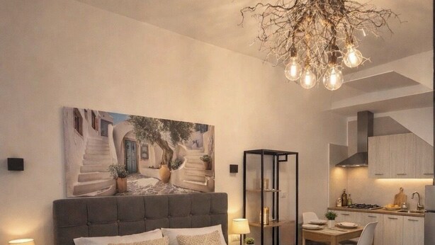 Un dormitorio con una cama grande, una zona de comedor y una cocina al fondo.