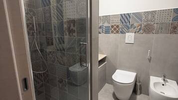 Een douche, een haardroger, een bidet, handdoeken