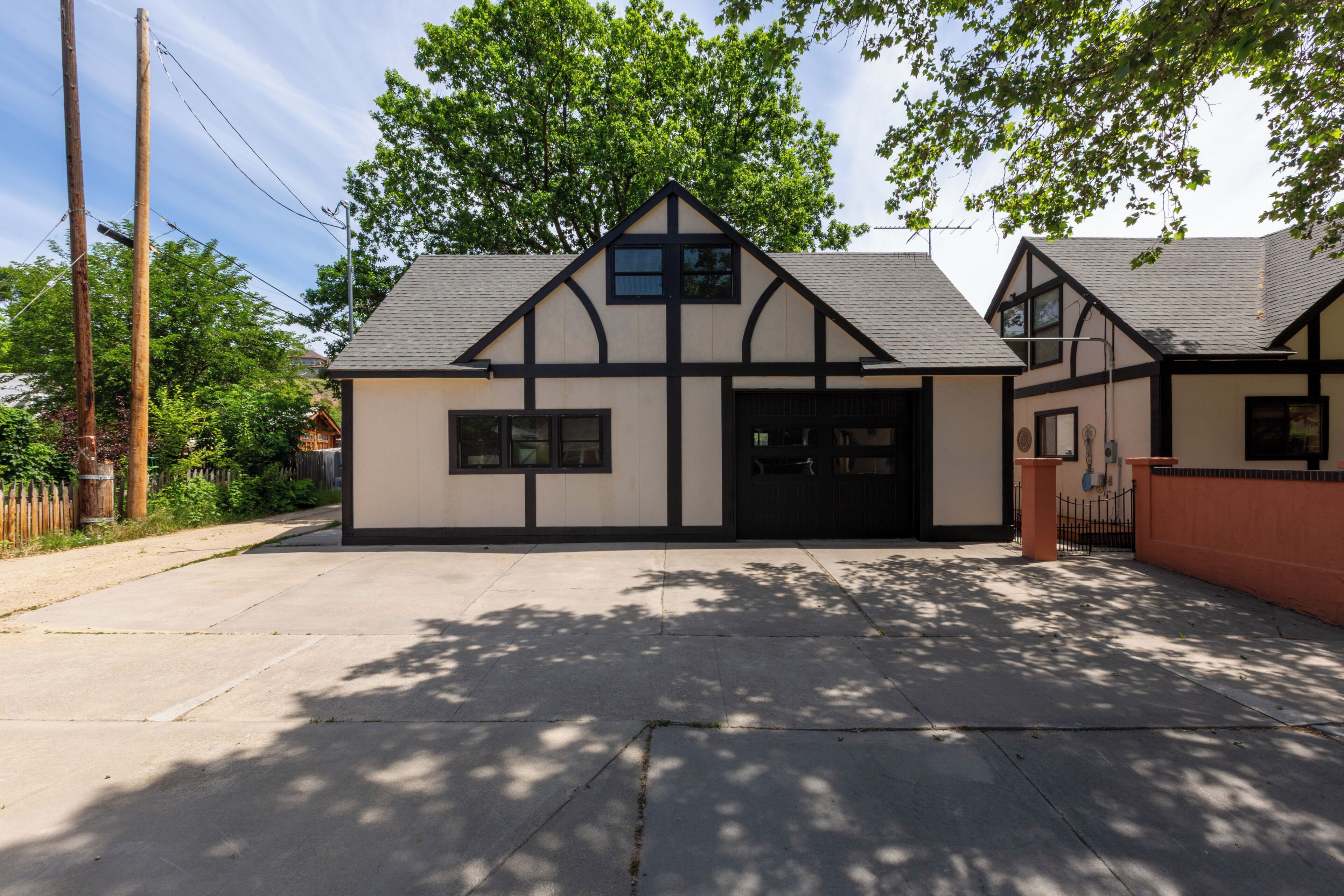 Ein zweistöckiges Haus im Tudor-Stil mit Garage, Vorgarten und Bürgersteig.