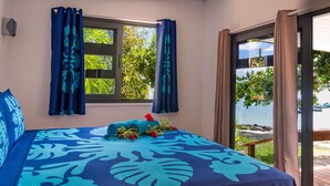 A room with a bed, a window with curtains, and a view of the outdoors. - MATIRA BEACH RAITEA I (Bora Bora)