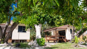 A tree-lined outdoor area with a building that has a covered patio and a visible entrance. - MATIRA BEACH RAITEA I (Bora Bora)