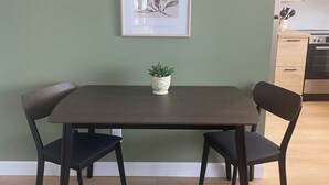 A dining area with a table and chairs, a framed artwork on the wall, and a potted plant on the table. - Cozy waterfront 2-bedroom cottage in peaceful Seeley's Bay with AC (Seeley's Bay)
