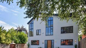 A modern two-story house with a paved driveway, large windows, and a brick entrance. - Glams luxury home (Wolverhampton)