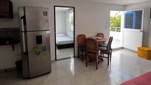 A compact living space with a kitchenette, a dining area, a bed, and a view through a door. - Casa AMA-Gi: 1 bedroom apartment in a family house. Terrace. Communal pool (SANTA MARTA)