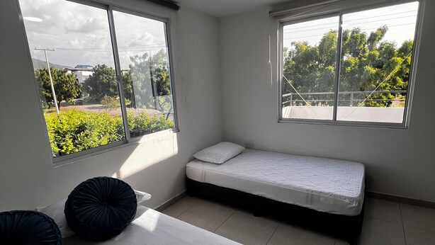 A room with a bed, a small sofa bed, large windows, and a view of greenery outside. - Casa AMA-Gi: 1 bedroom apartment in a family house. Terrace. Communal pool (SANTA MARTA)