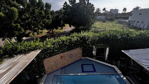 A swimming pool with a clear blue water feature, surrounded by a tiled deck and a brick wall. - Casa AMA-Gi: 1 bedroom apartment in a family house. Terrace. Communal pool (SANTA MARTA)