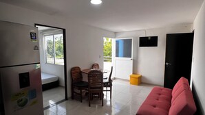 A compact living space with a kitchenette, dining area, and a sofa. - Casa AMA-Gi: 1 bedroom apartment in a family house. Terrace. Communal pool (SANTA MARTA)
