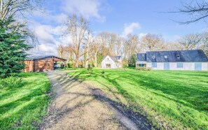 A rural property with a gravel driveway, a wooden shed, a white barn, and a large house with a sloped roof. - Maison neuve indépendante & plages (Clohars-Carnoët)