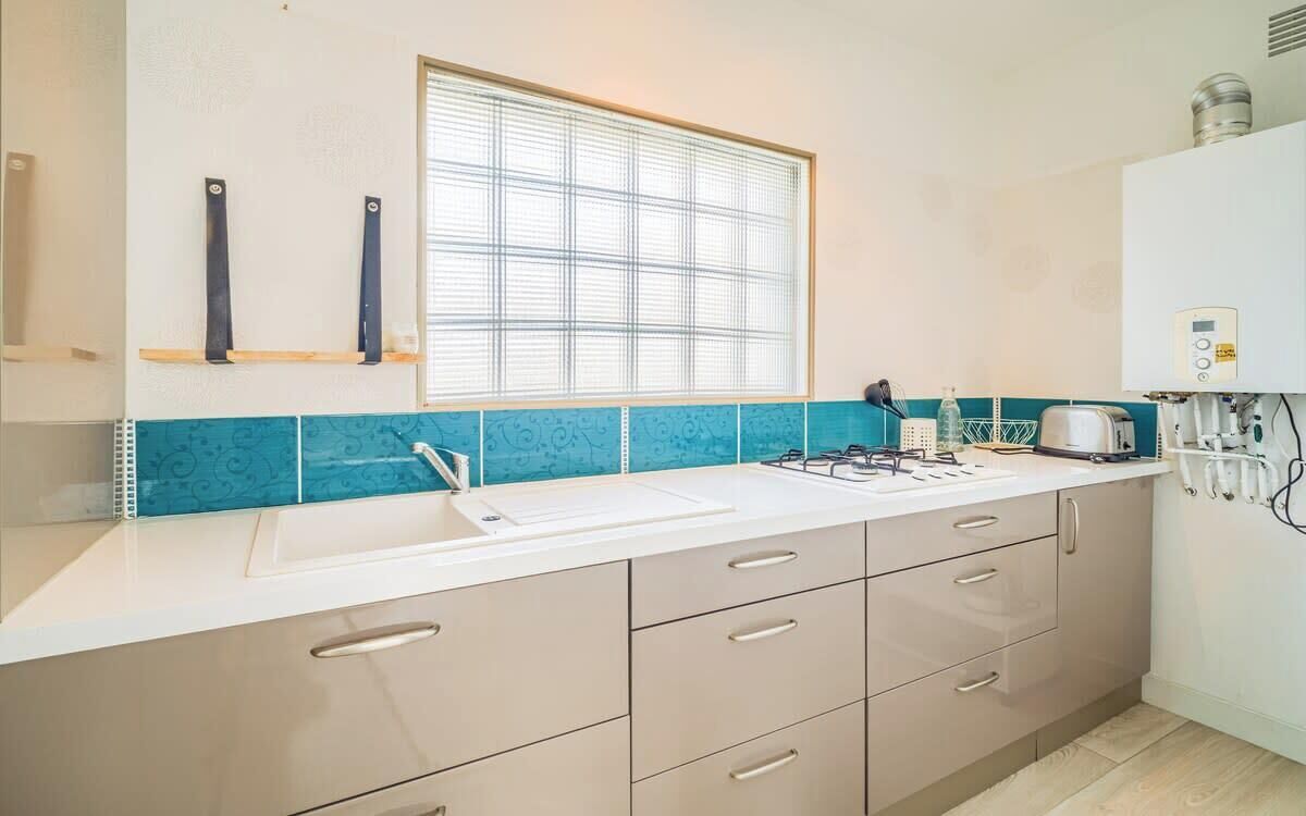 A kitchen with a window, a sink, a stove, and a countertop.