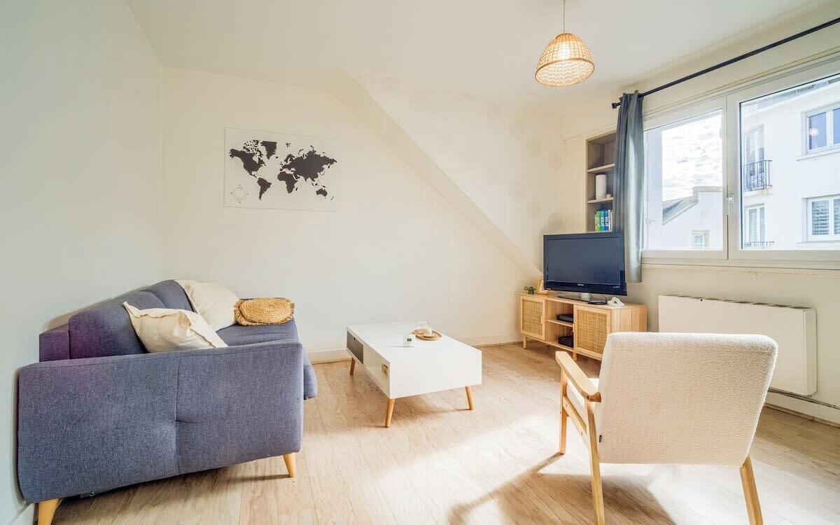 Een moderne woonkamer met een bank, een salontafel, een fauteuil, een televisie en een wereldkaart aan de muur.