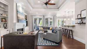 A spacious living room with a sectional sofa, a coffee table, and a fireplace. - 30A Getaway With Private Heated Pool, Hot Tub, and Golf Cart (Panama City Beach)