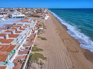 A coastal hotel with terracotta roofs, a sandy beach, and ocean views. - Las Olas II 2 | 3BR Beachfront Condo | Sleeps 7 (Puerto Peñasco)