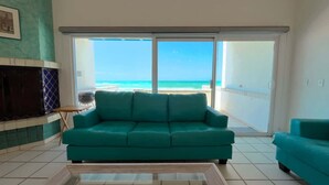 Un sofá azul turquesa en una sala de estar con vista al mar.