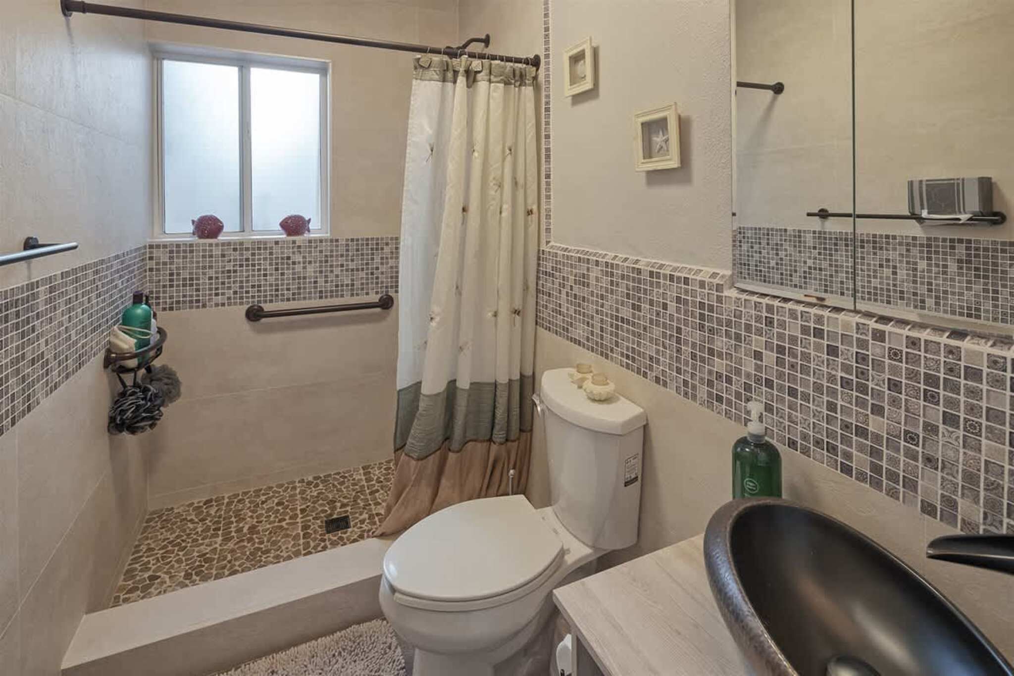 Ein Badezimmer mit Dusche, Toilette und Badewanne.