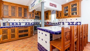 Een keuken met houten kastjes, een betegelde achterwand en een centraal eiland.