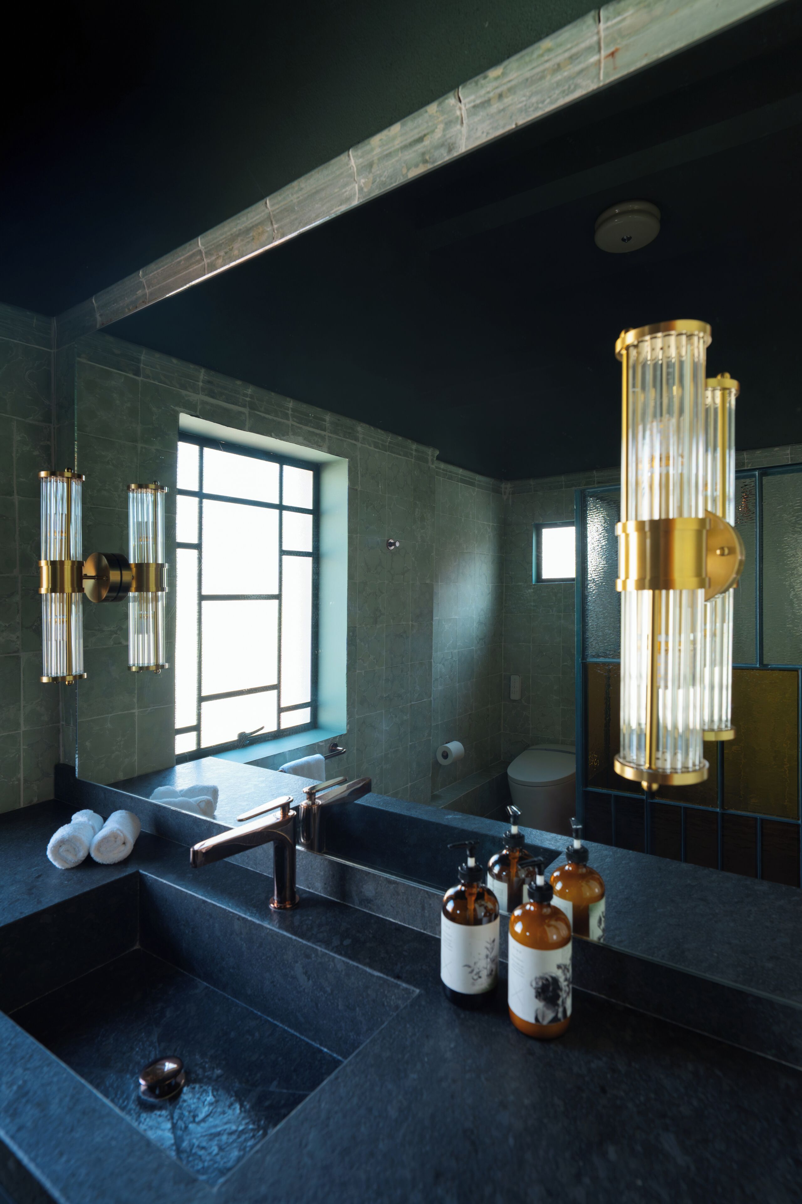 A modern bathroom with a large mirror, a bathtub, and a sink.