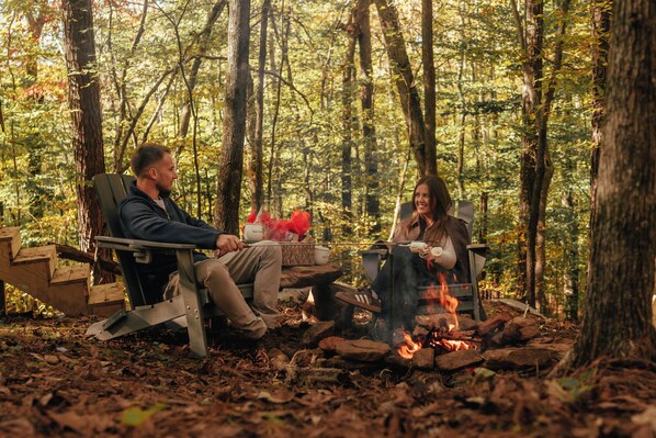 Two people sitting by a campfire in a forest. - Everlake Georgia (Covington)