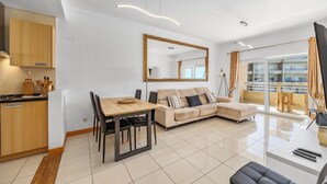 Ein modernes Wohnzimmer mit Essbereich, einer Couch und einem großen Spiegel.