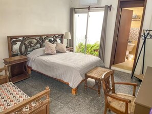 A bedroom with a bed, bedside table, chair, and a view of the outside. - Private Group Retreat • 350m to Olas Altas-Balcony & Stunning Views (Mazatlán)