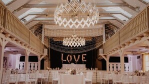 A spacious hall with a central stage, white chairs arranged in rows, and a chandelier. - Romantik Landhotel 3Kronen (Adelsdorf)