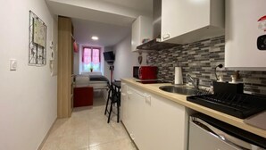 A modern kitchen with white cabinets, a tiled backsplash, and a built-in oven. - Aitzina Studio - Downtown (CAMBO LES BAINS)