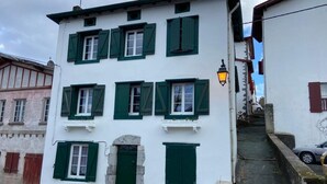 A white building with green shutters and a stone staircase leading to a door. - Aitzina Studio - Downtown (CAMBO LES BAINS)