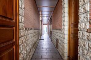A narrow hallway with brick walls and wooden doors. - L'instant Bayonnais - Downtown (BAYONNE)