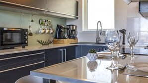 A modern kitchen with a built-in microwave, coffee maker, and kettle. - Le Lodge de Boucau - T2 with Balcony (BOUCAU)