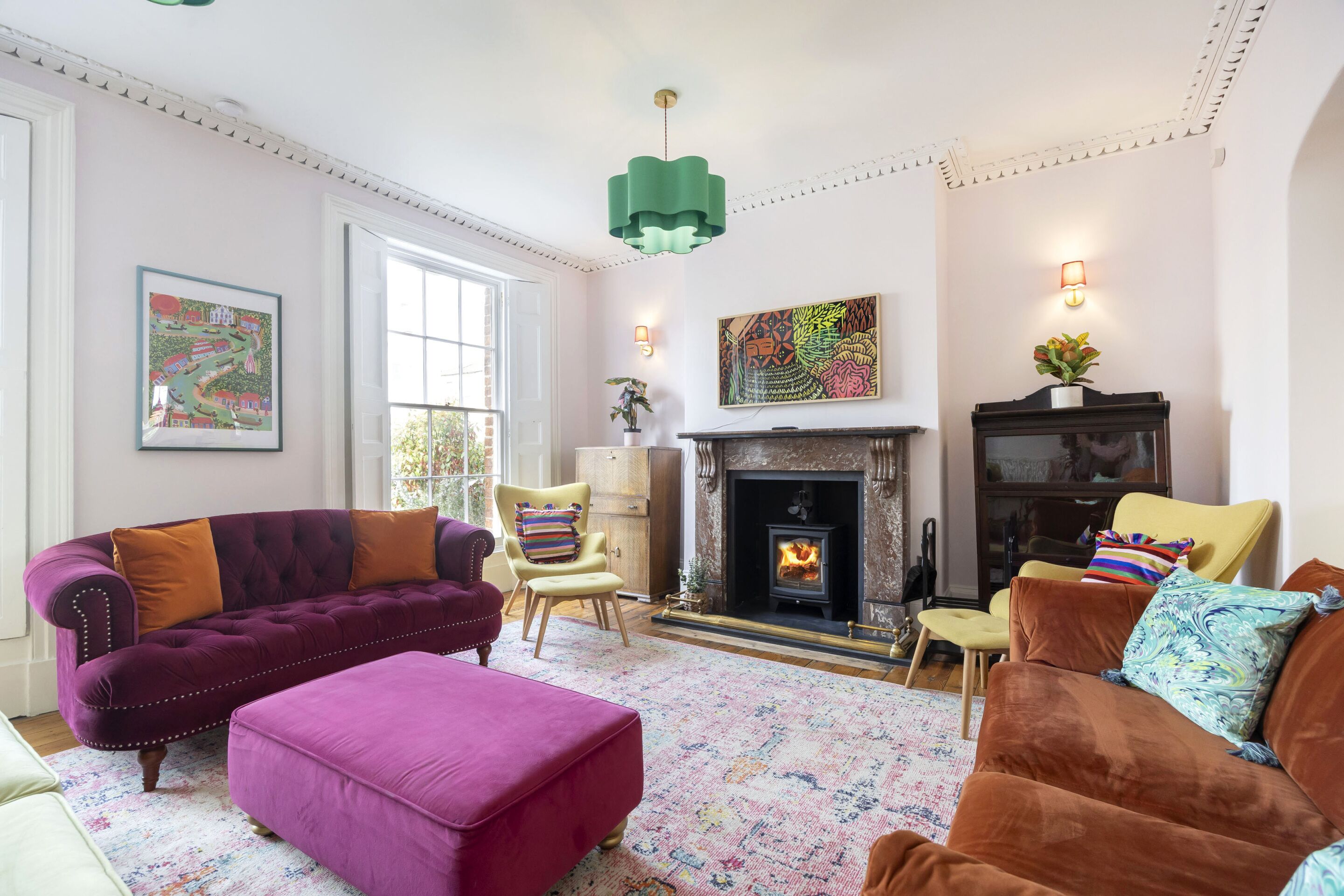 A living room with a fireplace, a sofa, a chair, and a rug.