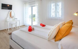 A hotel room with a bed, a desk, a mirror, and a TV on the wall. - Cozy home in Makarska (Makarska)