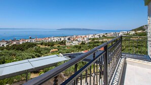 Un balcone con vista su una cittadina costiera, edifici e il mare.