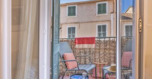 A balcony with two chairs, a small table, and a red towel. - Casa Saleccia – Appartement rénové au cœur de Saint-Florent (Saint-Florent)