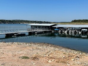A dock with boats, a pier, and a building with a roof. - The Lazy Lakehouse - All LVPOA Amenities Available (Lago Vista)