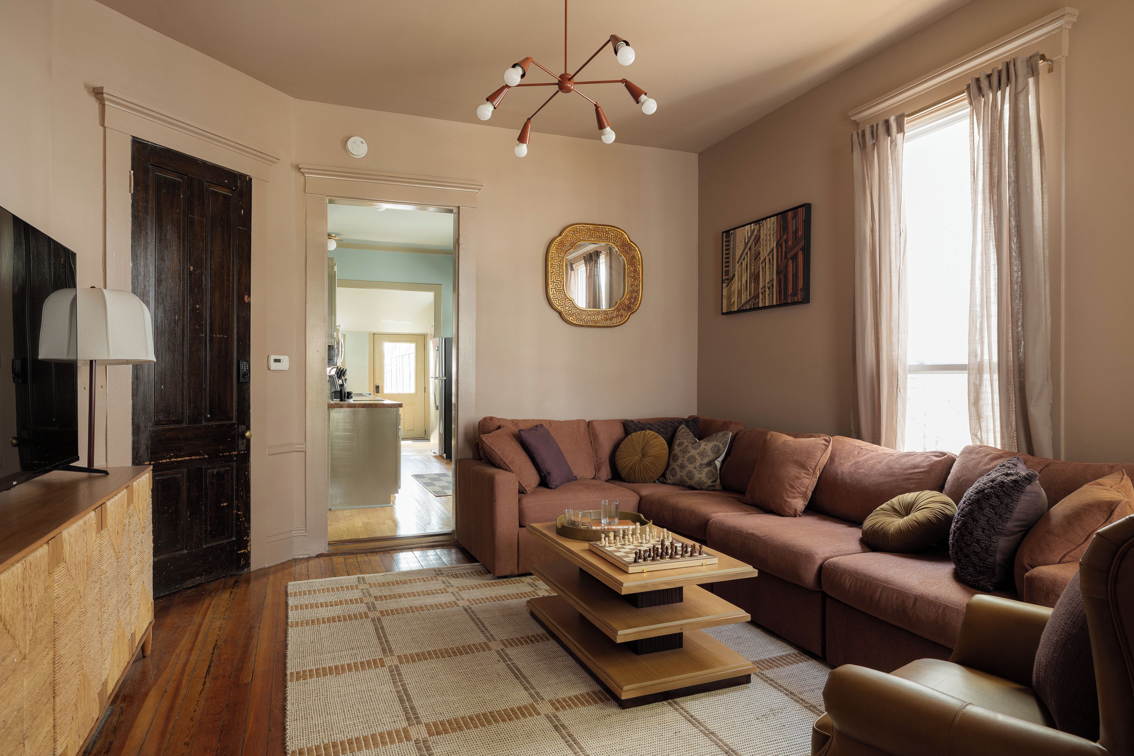 Living Room: Plush sectional, chess table, and mid-century flair!