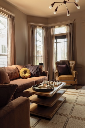 Sunlit Lounge: Bay windows, plush seating, and a chic game-night setup! - The Single Barrel - Deck, Fire Pit, Hot Tub, Games (Louisville)
